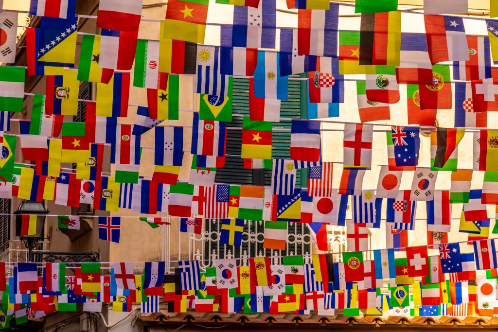 A selection of flags from around the world hanging between buildings. 