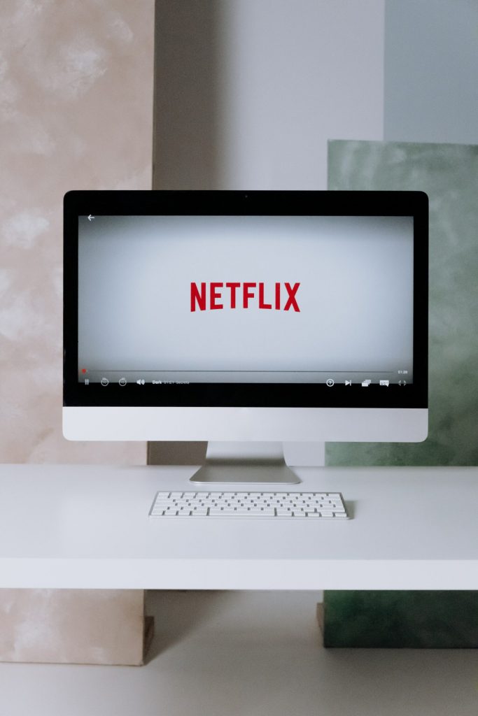 A Mac on a desk displaying the Netflix app. 