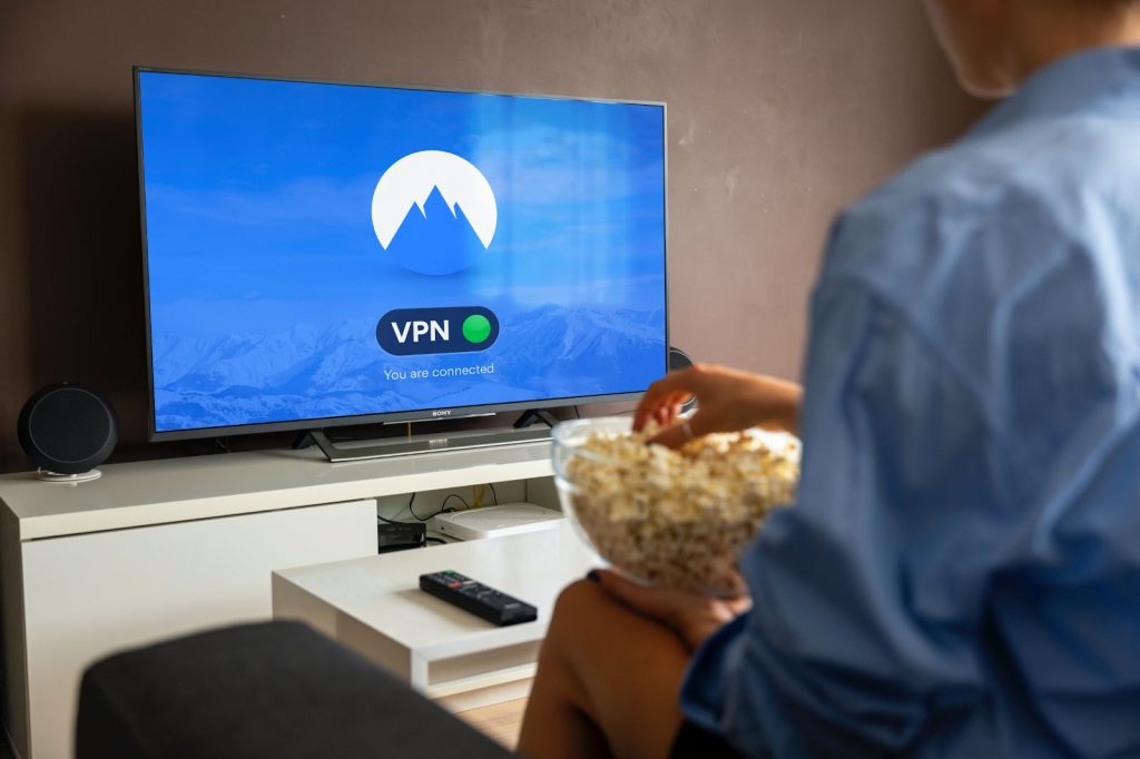 Someone sitting down with a bowl of popcorn to watch Nikita using NordVPN.